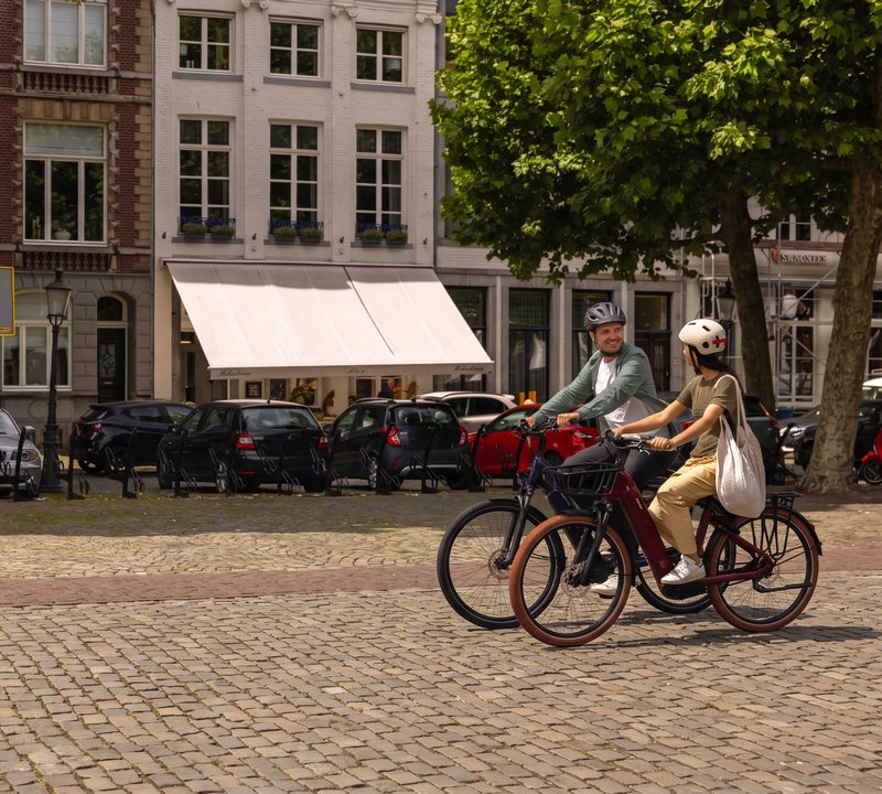 Twee mensen fietsen op Giant e-bikes door de stad
